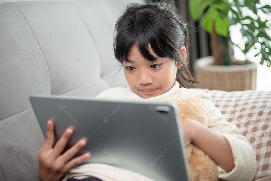 Menina usando tablet jogando na internet, Kid sitti