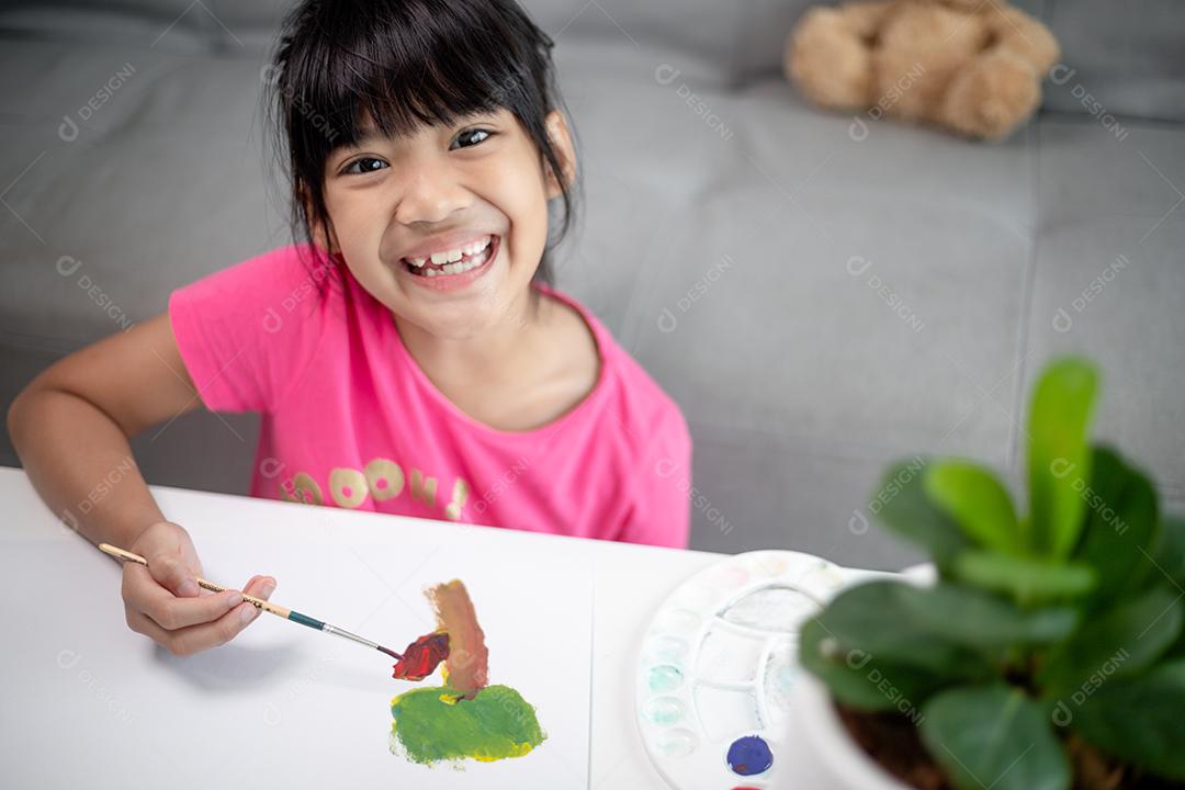 Menina pintando quadro na mesa em casa