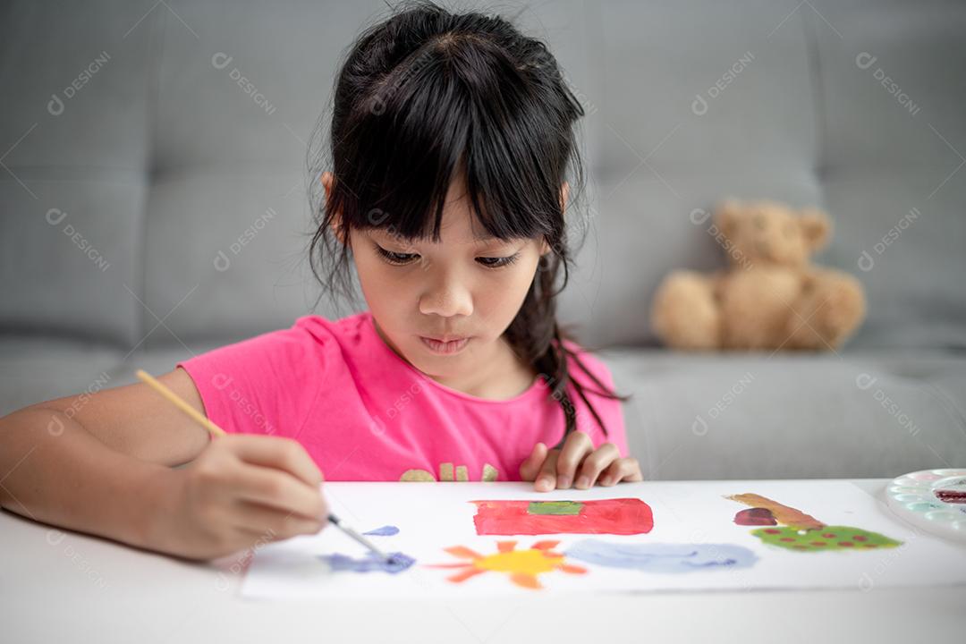 Menina pintando quadro na mesa em casa