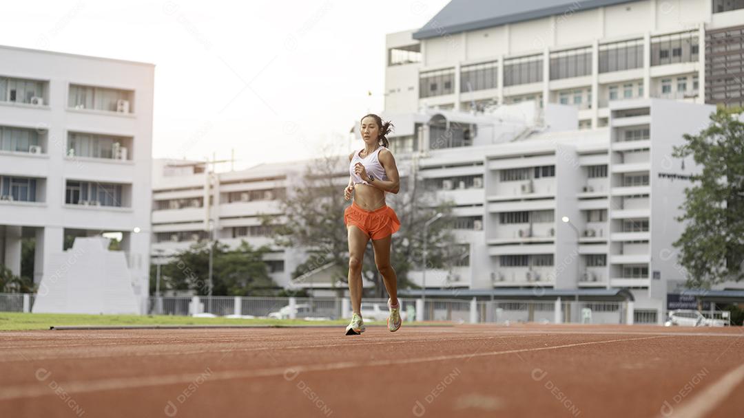 mulher correndo durante a manhã ensolarada na pista do estádio