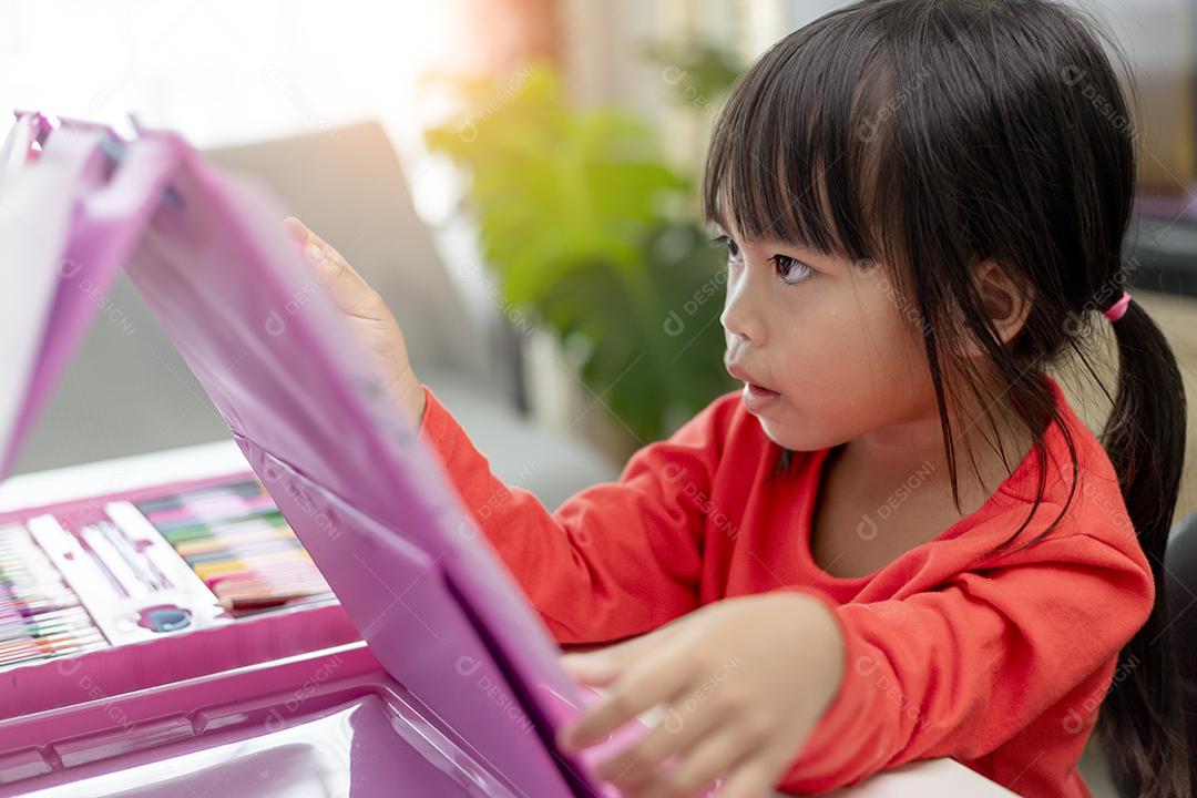 Menina asiática desenhando em casa o desenvolvimento da criatividade.