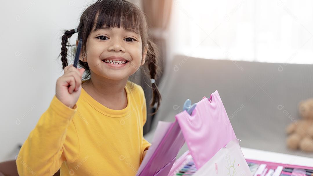 Menina asiática desenhando em casa o desenvolvimento da criatividade.