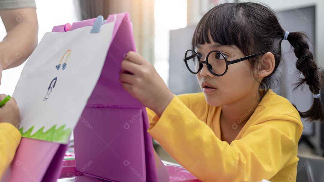 Menina asiática desenhando em casa o desenvolvimento da criatividade.