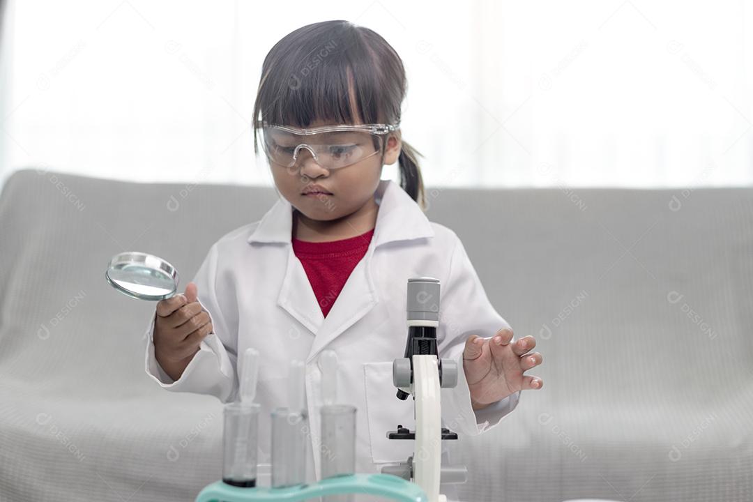 menina cientista aproveite e excite para examinar o produto químico de cor em laboratório usando conta-gotas com luz do dia. Conceito de boas práticas e educação da ciência para apoio às crianças.