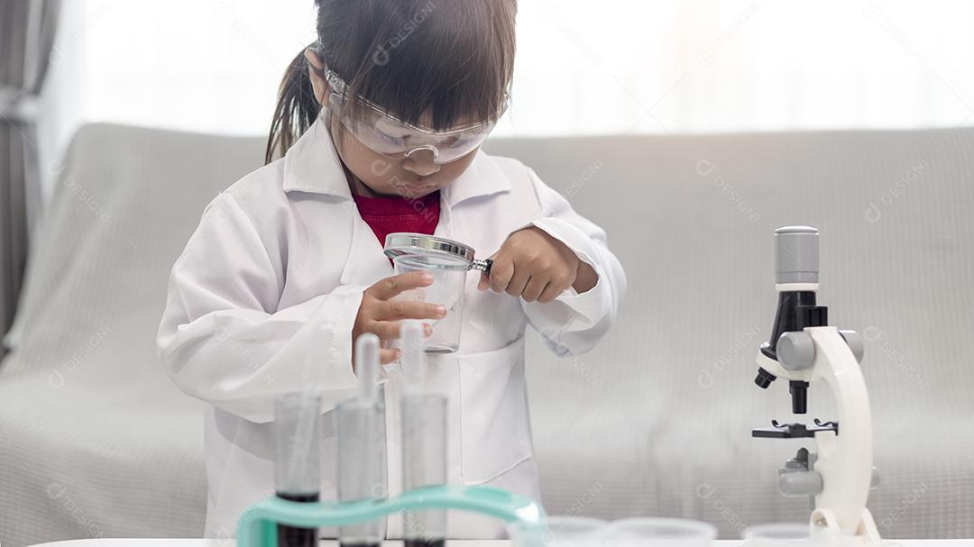 menina cientista aproveite e excite para examinar o produto químico de cor em laboratório usando conta-gotas com luz do dia. Conceito de boas práticas e educação da ciência para apoio às crianças.