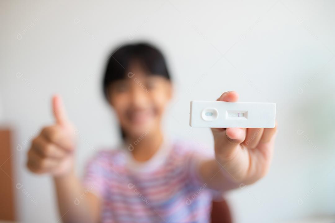 Menina asiática é testada para covid-19 antes da aula.