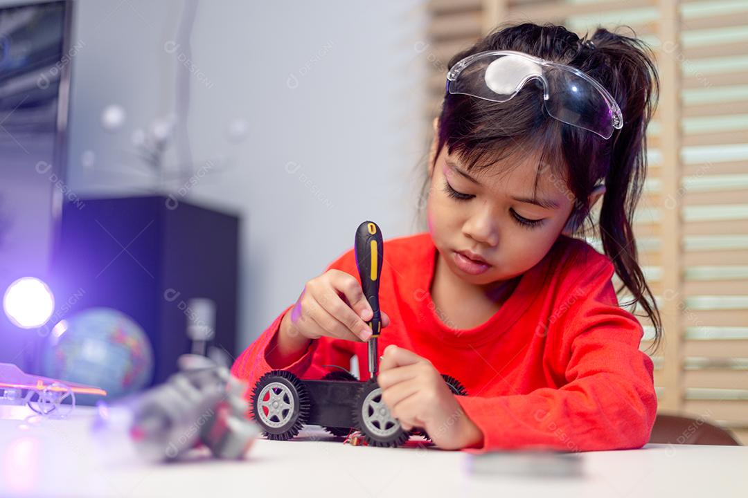 Os alunos da Ásia aprendem em casa na codificação de carros robóticos e cabos de placas eletrônicas em STEM, STEAM, código de computador de tecnologia de ciência de engenharia matemática em robótica para o conceito de crianças.