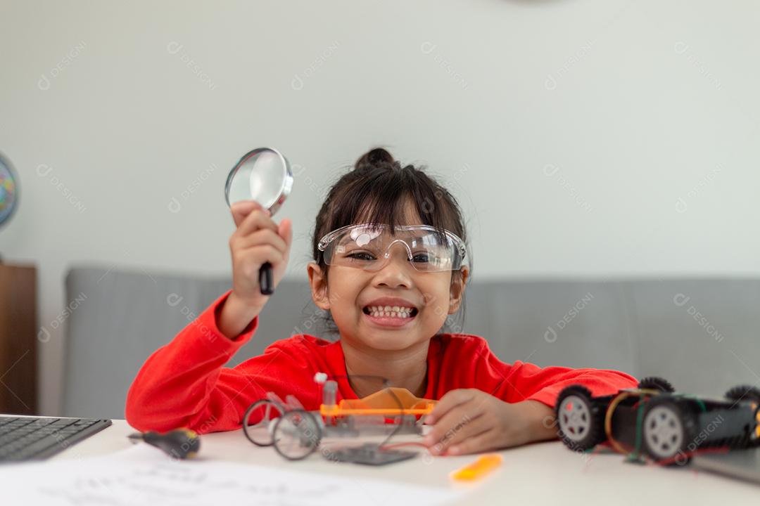 Os alunos da Ásia aprendem em casa na codificação de carros robóticos e cabos de placas eletrônicas em STEM, STEAM, código de computador de tecnologia de ciência de engenharia matemática em robótica para o conceito de crianças.