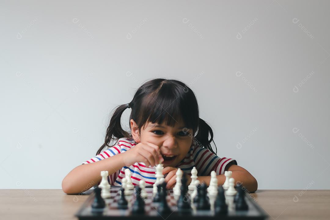 Menina asiática jogando xadrez em casa. um jogo de xadrez