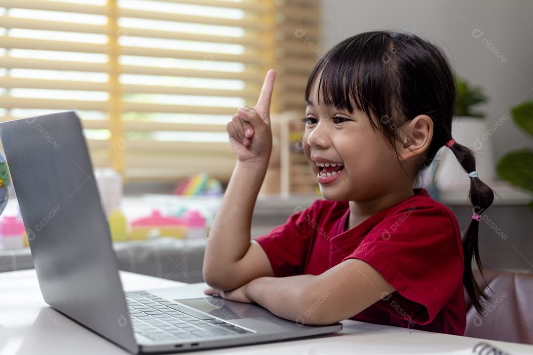 Menina asiática usando computador portátil para estudo on-line em casa durante a quarentena em casa. ensino em casa, estudo on-line, quarentena em casa, aprendizado on-line, vírus corona ou conceito de tecnologia educacional