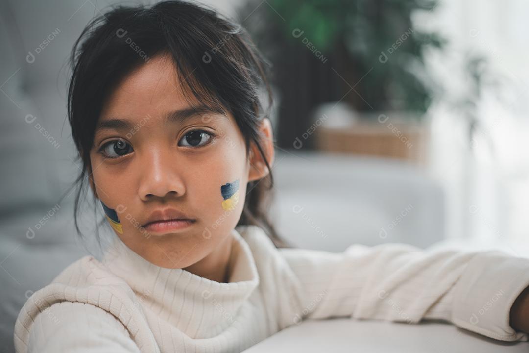 Uma criança com a bandeira da Ucrânia está chorando. Tristeza desejando esperança. As lágrimas das crianças da guerra. Evacuação de civis. Liberdade para a Ucrânia