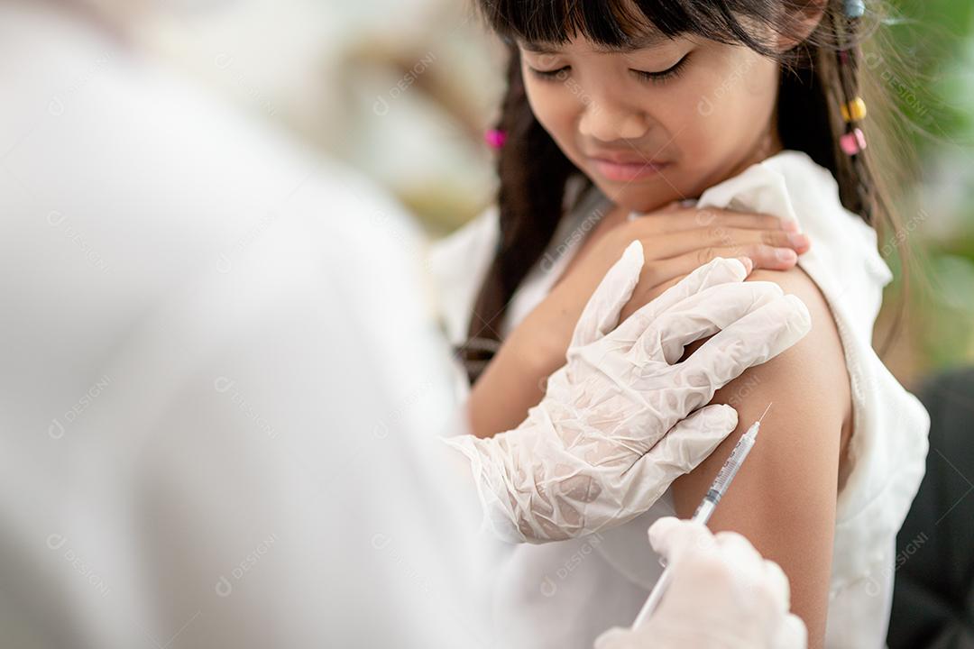 Conceito de vacinação. Médica vacinando menina bonitinha na clínica