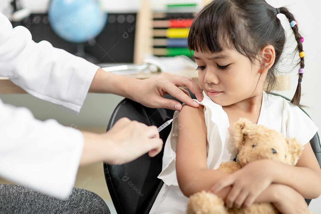 Conceito de vacinação. Médica vacinando menina bonitinha na clínica