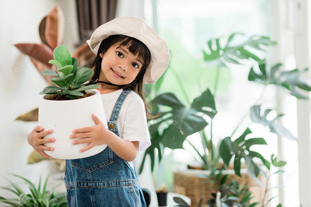 Plantas em vasos em casa mantidas por uma linda criança