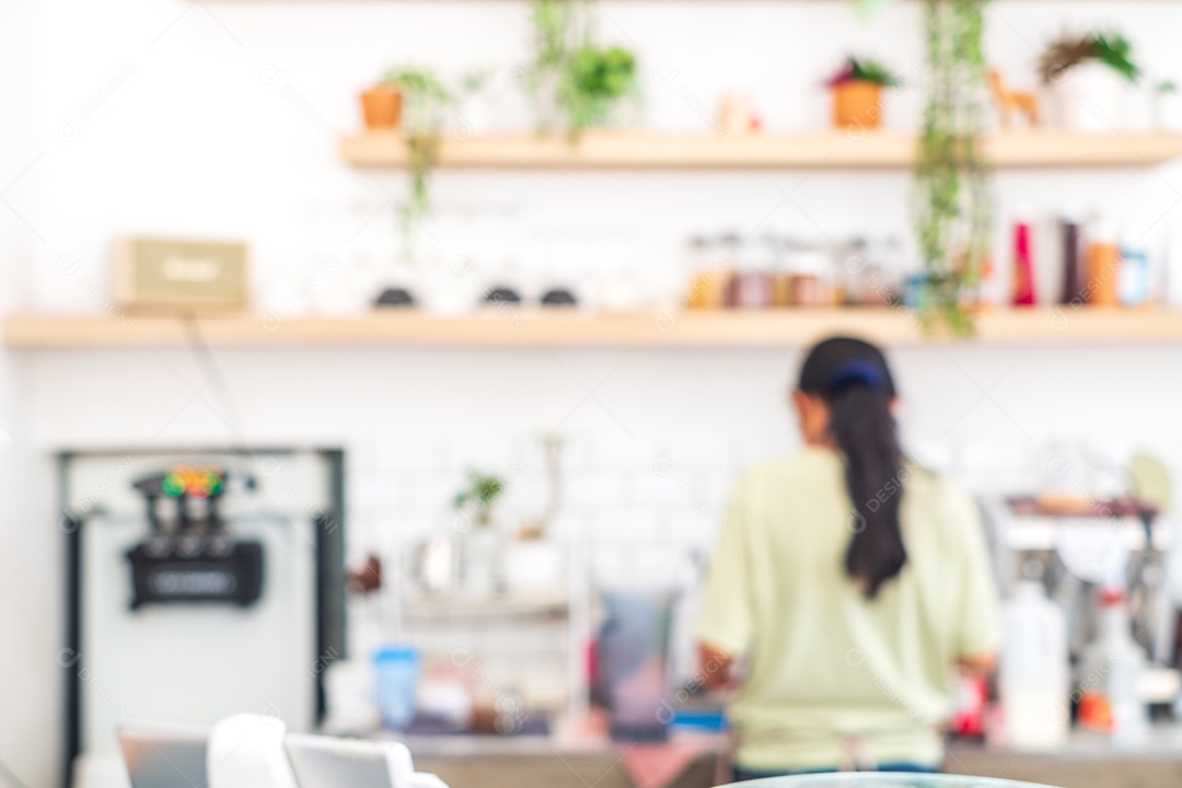 Desfocado de trabalhadora fazendo café em uma cafeteria