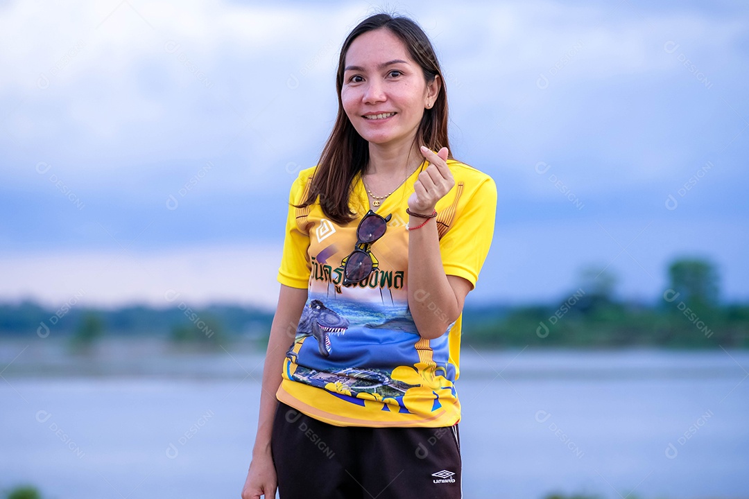 Mulher fazendo gestos mãos sobre fundo lago