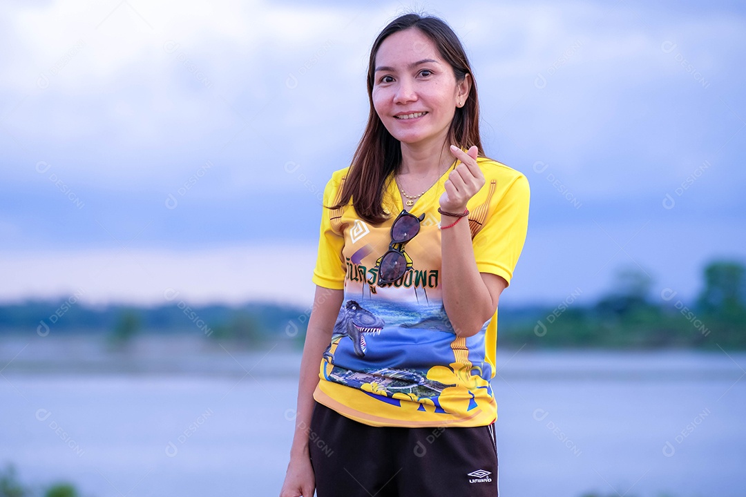 Mulher fazendo gestos mãos sobre fundo lago