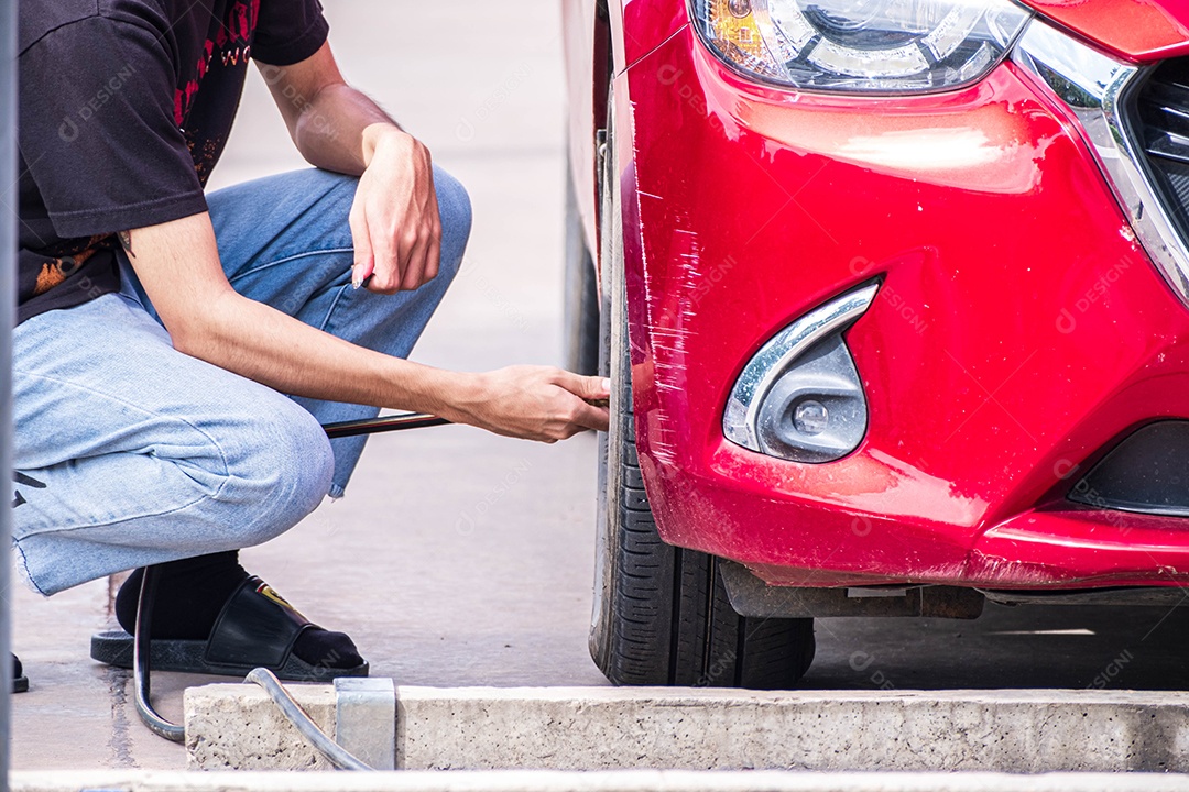 homem inflando pneu de carro vermelho em um centro de serviço