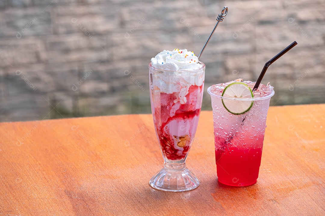 Suco vermelho, refrigerante Red água-limão refrigerante com slide de limão e sorvete de morango com cobertura de creme na mesa de madeira e fundo desfocado