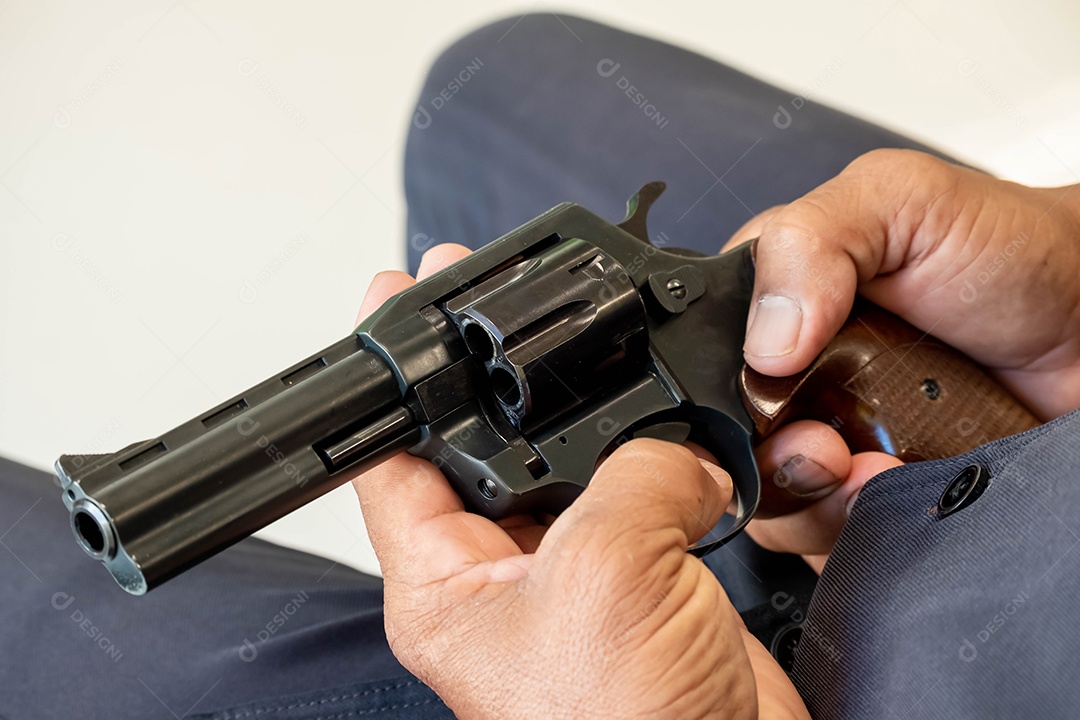 Pistola automática preta, cabo de pistola marrom. feito de material de qualidade Nas mãos de um homem vestindo um vestido preto