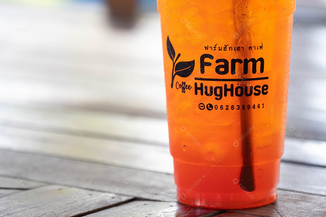 Plastic cup with a straw on a wooden table