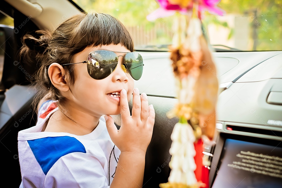 Linda criança garotinha usando óculos escuro sobre carro automóvel