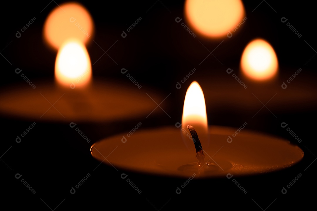 Velas do copo que são acesas no escuro, luz sagrada, velas acesas na superfície escura. Dia da memória
