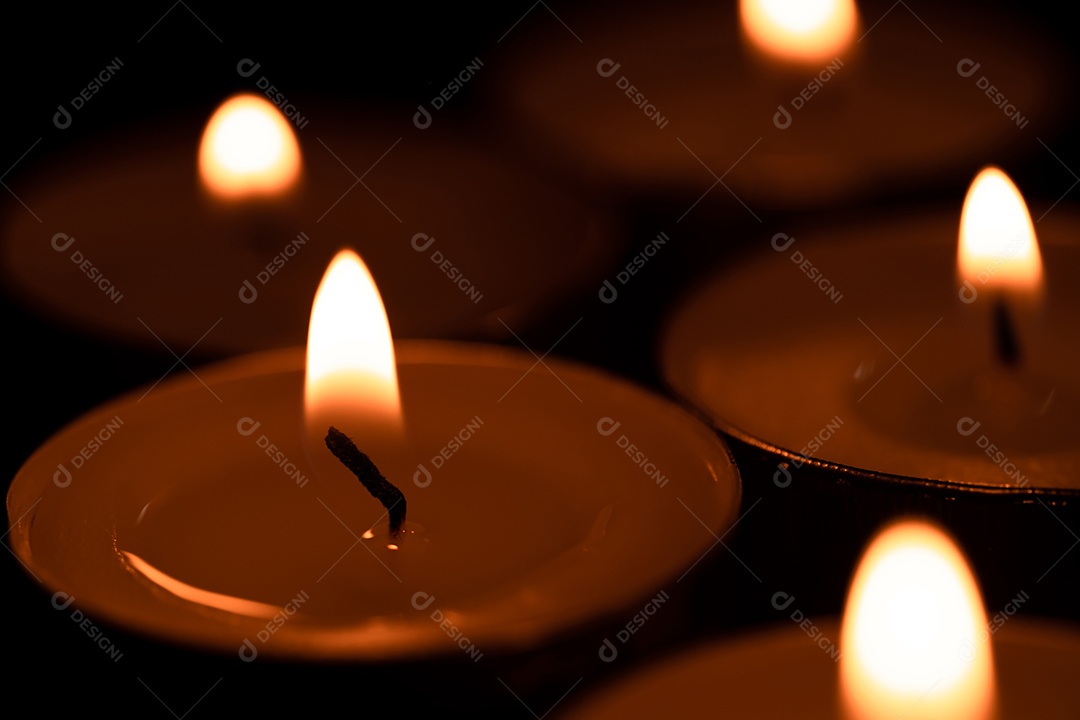 Velas do copo que são acesas no escuro, luz sagrada, velas acesas na superfície escura. Dia da memória