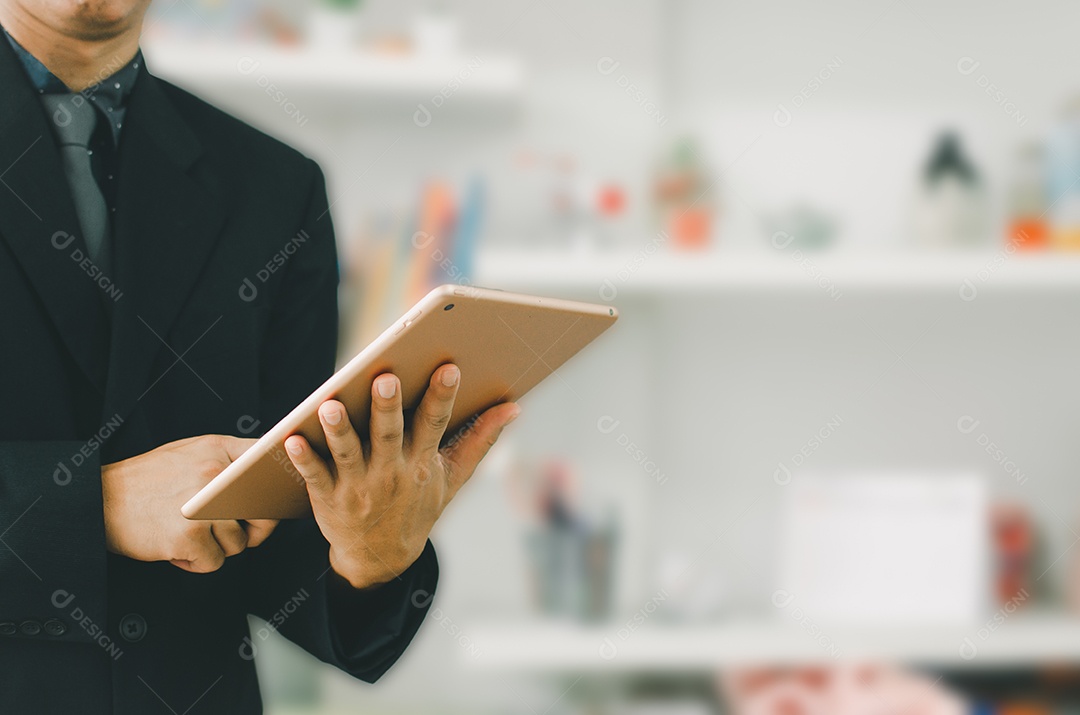 Empresário segurando um tablet para procurar informações e fazer negócios online.