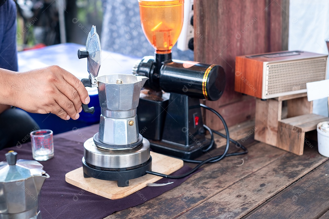 Mão segurando o pote de moka clássico italiano, estilo vintage de café