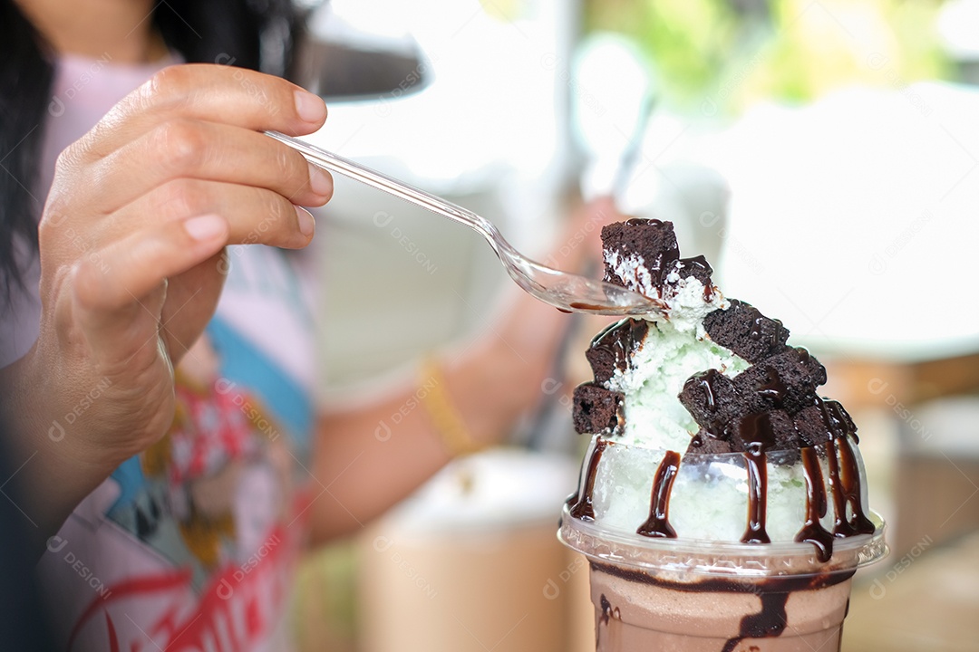 Mulher usando colher para comer sorvete milk shake