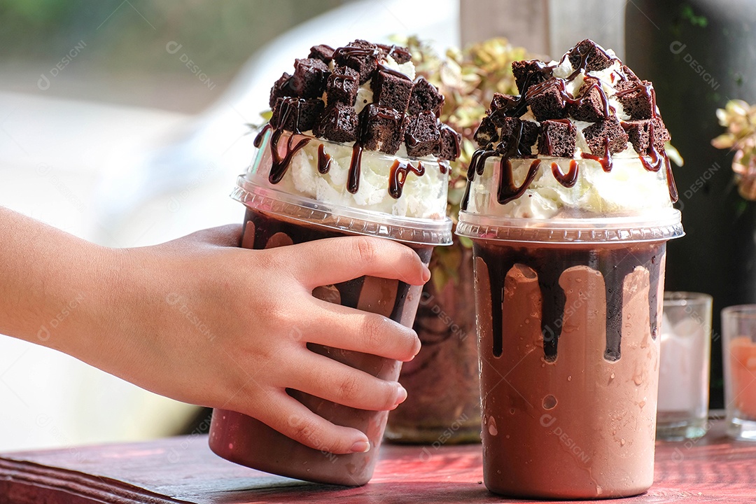 Mão segurando uma xícara de cacau gelado, café, cacau, brownies, cafeteria