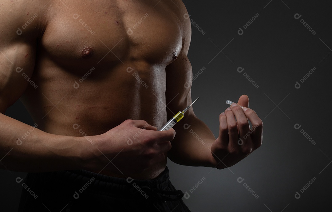 Homem musculoso com uma seringa na mão. Usuário de esteroides anabolizantes para treinamento de força