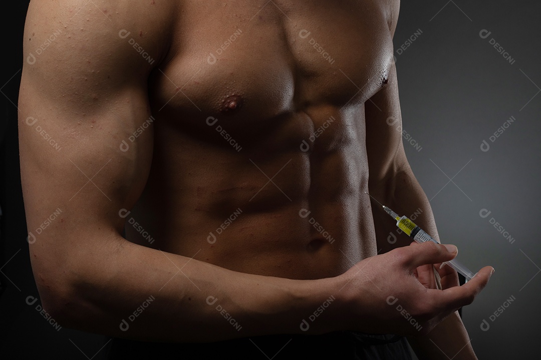Homem musculoso com uma seringa na mão. Usuário de esteroides anabolizantes para treinamento de força