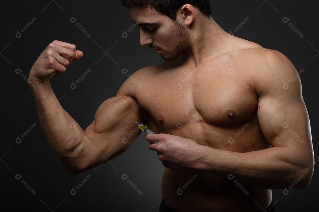 Homem musculoso com uma seringa na mão. Usuário de esteroides anabolizantes para treinamento de força