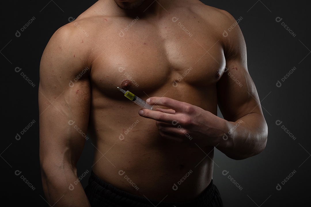 Homem musculoso com uma seringa na mão. Usuário de esteroides anabolizantes para treinamento de força