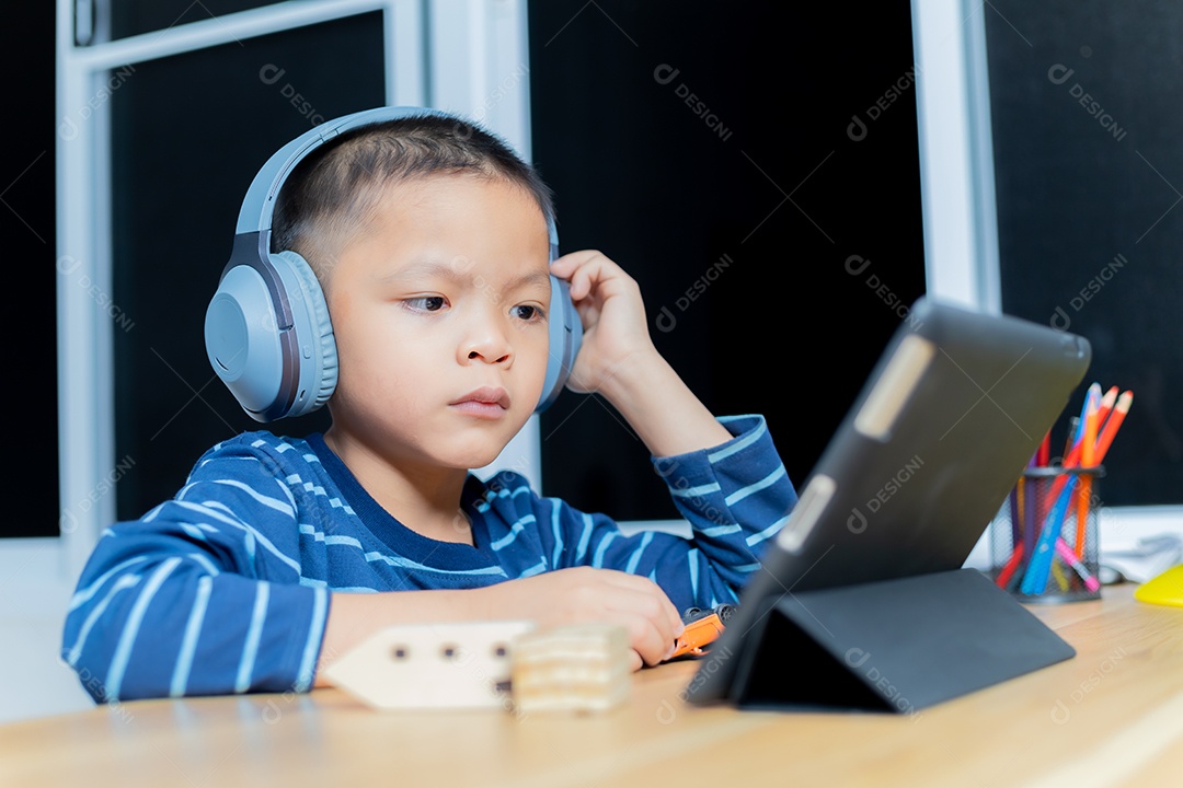 As crianças estudam online através de tablets em casa.