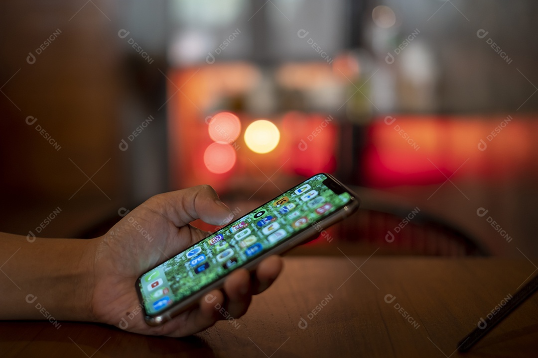 smartphone na mão, jogando o smartphone na cafeteria, mostre o bokeh atrás da luz da vela, pegue Phon, Khonkean, Tailândia, 19 mach 2021
