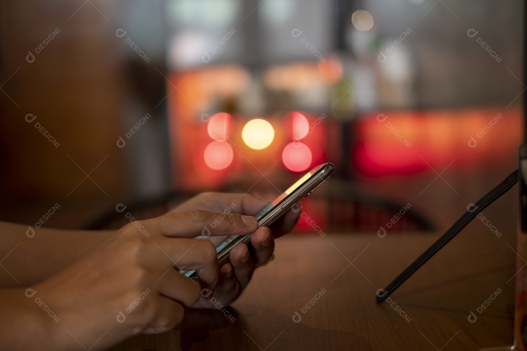 smartphone na mão, jogando o smartphone na cafeteria, mostre o bokeh atrás da luz da vela, pegue Phon, Khonkean, Tailândia, 19 mach 2021