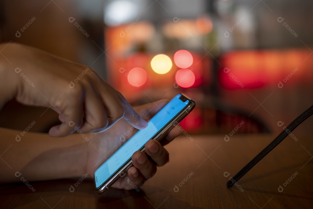 smartphone na mão, jogando o smartphone na cafeteria, mostre o bokeh atrás da luz da vela, pegue Phon, Khonkean, Tailândia, 19 mach 2021