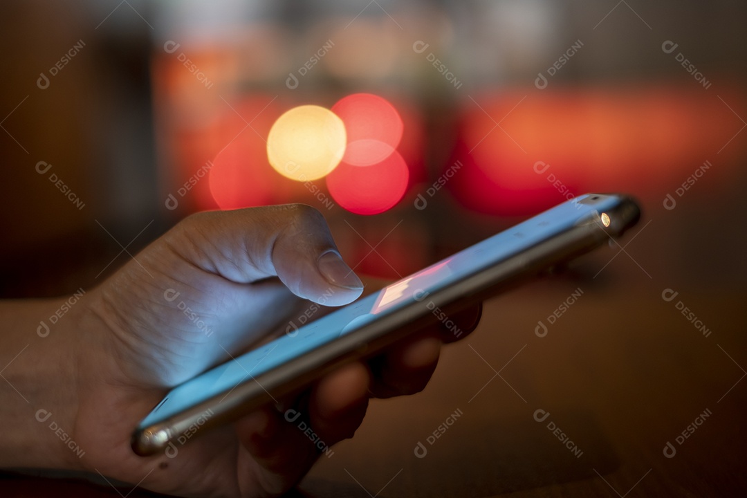 smartphone na mão, jogando o smartphone na cafeteria, mostre o bokeh atrás da luz da vela, pegue Phon, Khonkean, Tailândia, 19 mach 2021