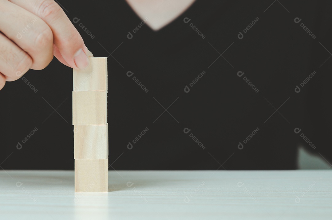 Mão colocando e empilhando cubos de madeira em branco para ícones ou símbolos.