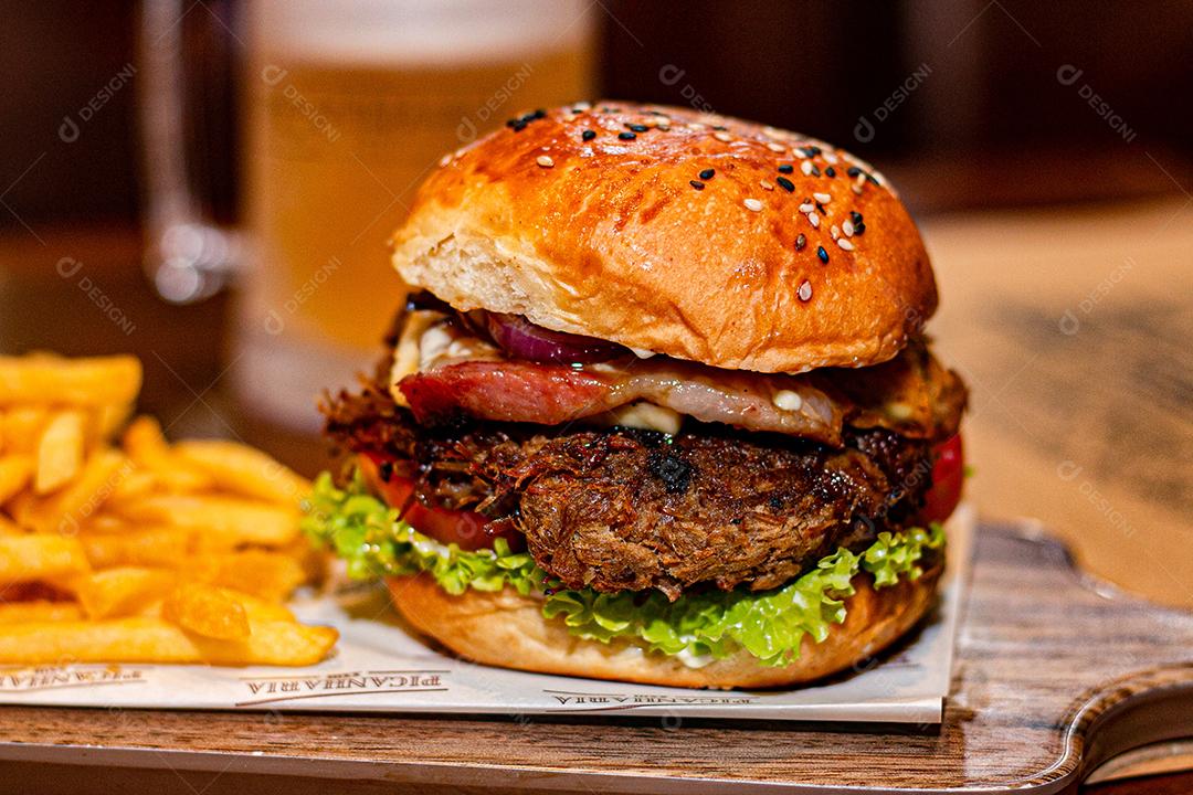Hambúrguer com batata frita servidos em tabua de madeira