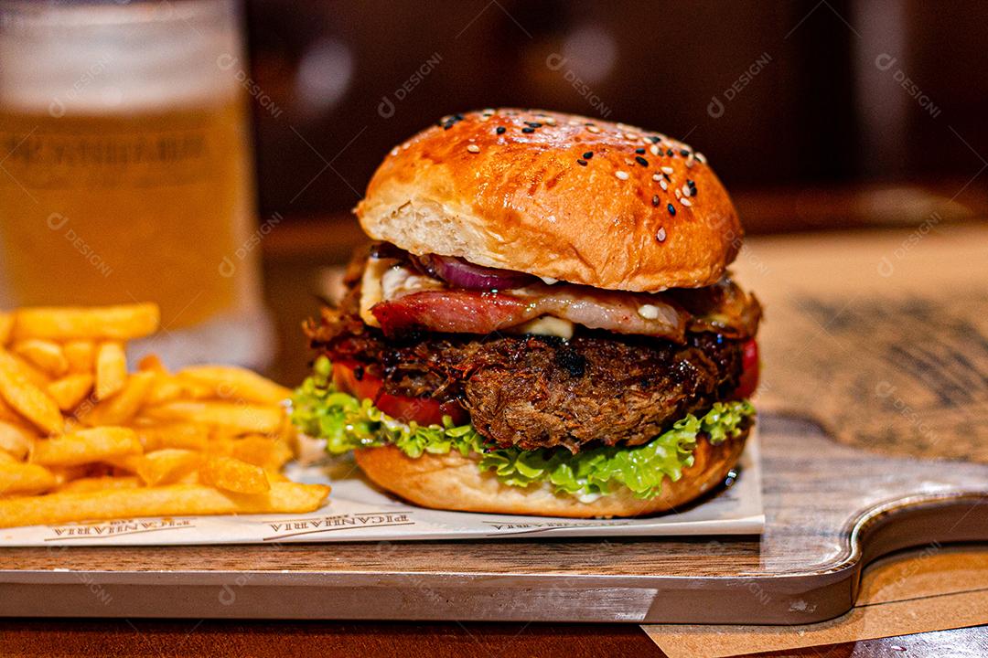 Hamburger with french fries served on a wooden board