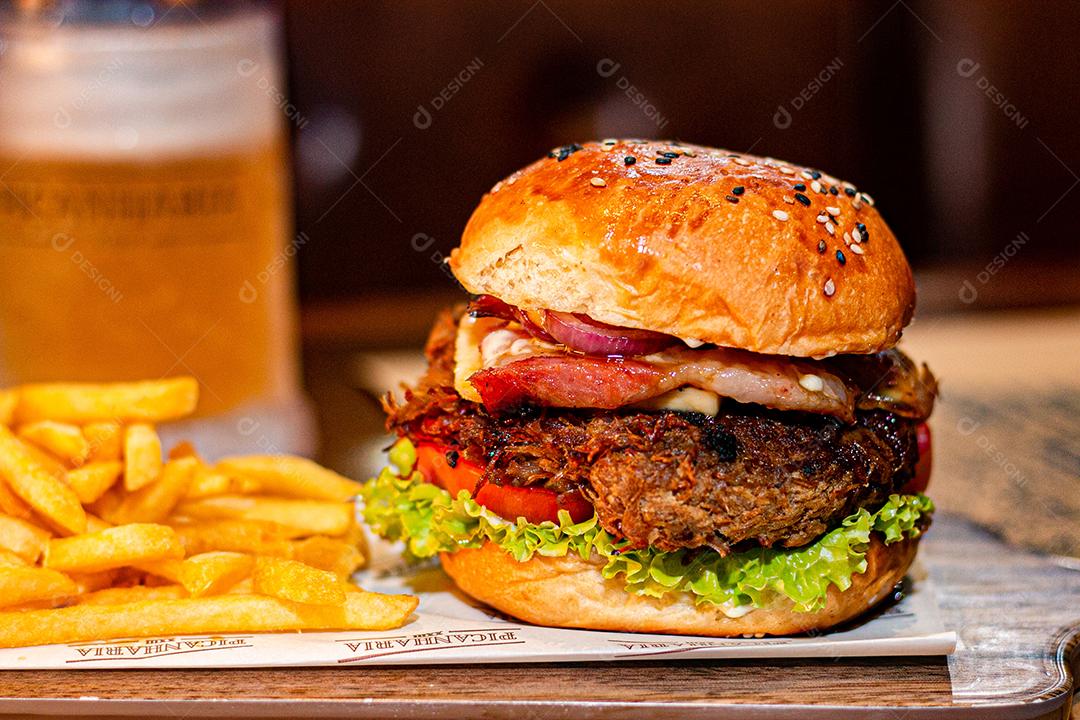 Hambúrguer com batata frita servidos em tabua de madeira