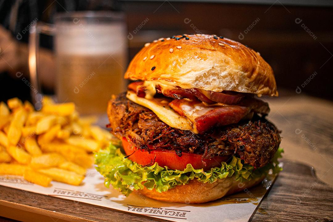 Hambúrguer com batata frita servidos em tabua de madeira