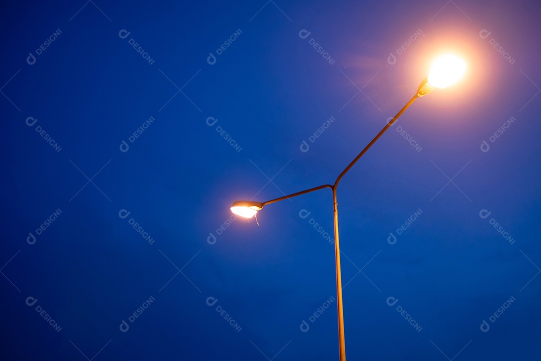 Lâmpada iluminando a estrada ao entardecer