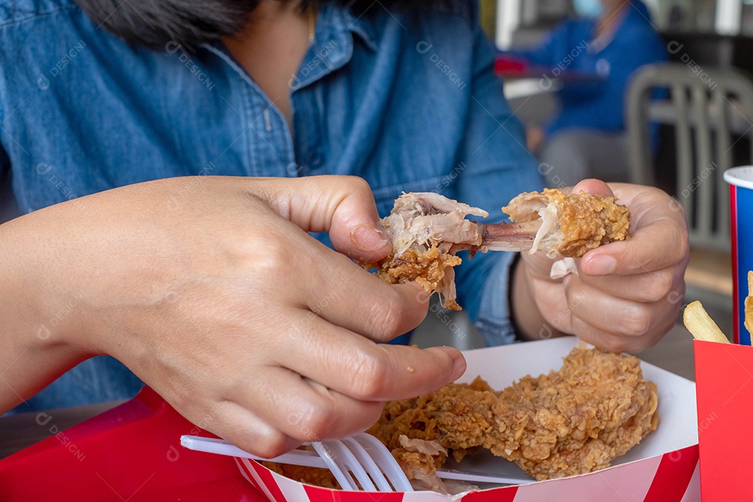 comendo frango frito na mão em restaurante de fast food, junk food