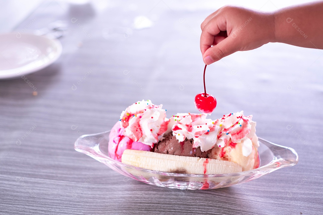 Sundae doce caseiro de banana split com sorvete de chocolate baunilha e morango