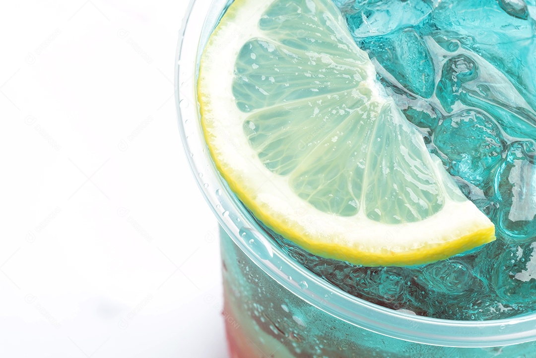 Fatias de limão são colocadas em um copo de água azul fria.